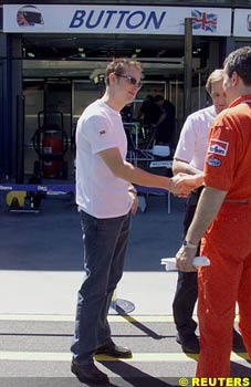 Button at his pits in Melbourne, welcomed by a Ferrari mechanic