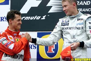 Michael Schumacher and Mika Hakkinen shake hands on the podium