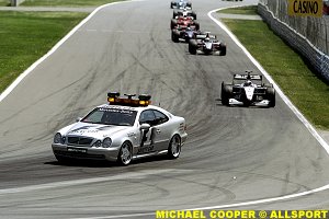 The safety car leads the field