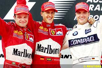 Ferrari driver Michael Schumacher joins second placing team mate Rubens Barrichello of Brazil and younger brother, Williams driver Ralf on the podium March 12, 2000