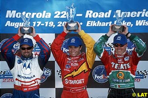 Michael Andretti, Bruno Junqueira and Adrian Fernandez hold their trophies up high