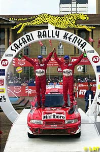 Makinen and Mannisenmaki stand on the bonnet of their victorious Lancer