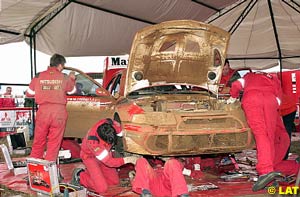 Dust covers the Lancer of winner Makinen at a service park