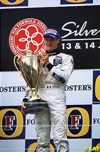 Sebastien Bourdais holds onto a very large winner's trophy