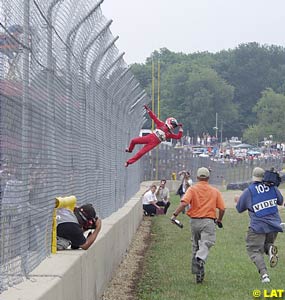 Helio Castroneves goes climbing fences again