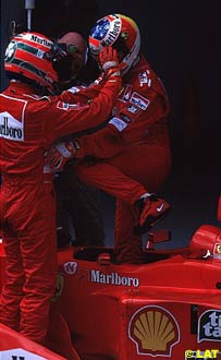 Eddie Irvine thanking Michael Schumacher for the victory in the parc ferme, Malaysian Grand Prix, Sepang, 1999