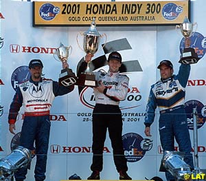 Second placed Michael Andretti, left, and Alex Tagliani, right, hold their trophies aloft with winner Cristiano da Matta, centre
