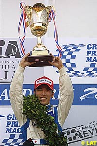 Winner Takuma Sato holds the trophy aloft