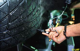 A Bridgestone tyre technician checking a wet weather tyre