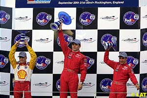 The podium at Rockingham, with 2nd placed Kenny Brack celebrating with Penske teammates winner Gil de Ferran and 3rd placed Helio Castroneves who was later demoted to 4th