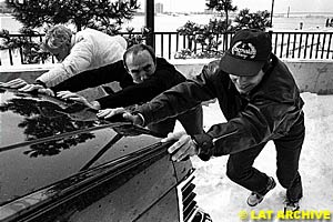 Frank (middle) and Nelson Piquet push a car out of the snow in  Detroit, 1982