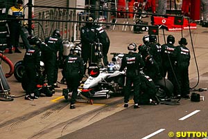 Raikkonen waits for his mechanics to get the tyres