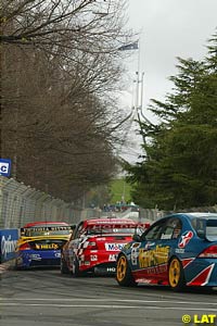 The cars race through the Canberra streets towards the flag on top of Australia's Parliament House