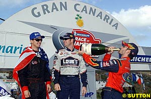 Colin Edwards and Jimmie Johnson laugh as a thirsty Jeff Gordon celebrates their Nations Cup victory