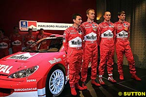 Peugeot's pilots Gilles Panizzi, Harri Rovanpera, 2000 and 2002 World Champion Marcus Gronholm and 2001 World Champion Richard Burns stand beside their newly-liveried car