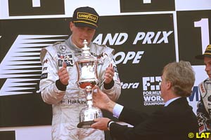 Mosley hands Hakkinen the trophy on the podium at Jerez 1997