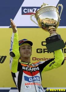 Valentino Rossi smiles as he holds holding the winner's trophy