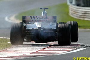 A McLaren rides the kerbs