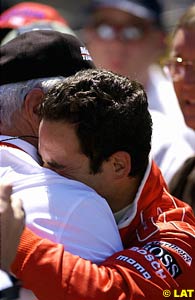 Helio Castroneves is comforted by team boss Roger Penske after their back-to-back victories