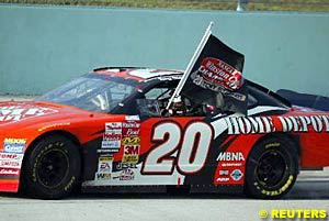 2002 NASCAR Winston Cup Champion Tony Stewart celebrates with a flag