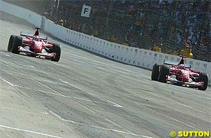 Barrichello and Schumacher cross the finish line at Indy