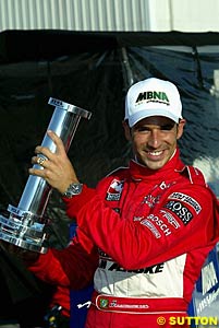 Helio Castroneves holds onto his winner's trophy, his first win after a long drought