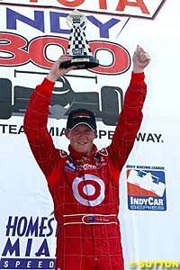 Scott Dixon holds the winner's trophy up in his first IRL race