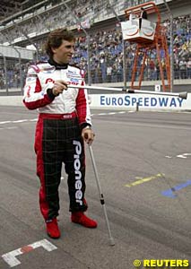 Alex Zanardi stands at the start/finish line with his walking sticks before his drive