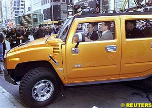 Arnold Schwarzenegger drives a new Hummer H2 over a curb in New York 