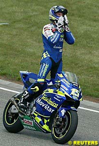Sete Gibernau stands as he returns to the pits on his cooldown lap after taking victory in the final metres