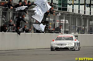 Christijan Albers takes the win with the Mercedes crew waving their flags in celebration