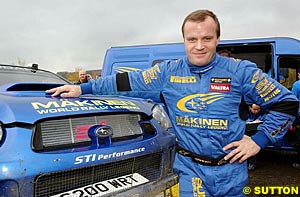 Tommi Makinen with 'Makinen World Rally Legend' on his car and his overalls