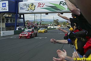 The two Monaros take the chequered flag less than half a second apart after 24 hours