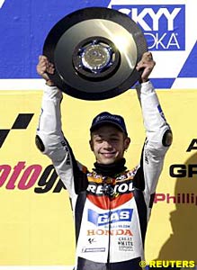 Valentino Rossi holds the winner's trophy aloft
