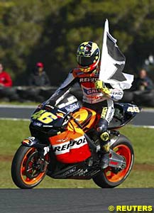 Valentino Rossi rides the victory lap with the black and white number seven flag over his shoulder