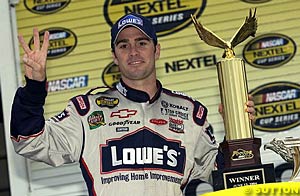 Jimmie Johnson holds the winner's trophy after winning at Pocono
