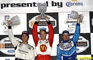 Second place finisher Bruno Junqueira, winner Sebastien Bourdais and third place finisher Patrick Carpentier celebrate on the podium
