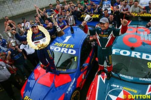 2004 V8 Supercar Champion Marcos Ambrose and runner up Russell Ingall stand on the bonnet of their cars in celebration of a successful 2004