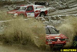 Third place Colin McRae (background) and second place Stephane Peterhansel splash through the muddy snow on the prologue at Clermont-Ferrand
