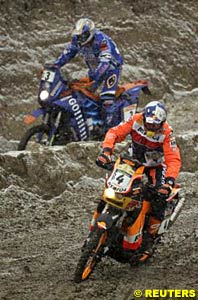 Pre-event favourite Fabrizio Meoni (background) and motorcycle leader Nani Roma splash through the muddy snow on the prologue at Clermont-Ferrand