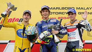 Second place finisher Max Biaggi, winner Valentino Rossi and third place finisher Alex Barros celebrate on the podium
