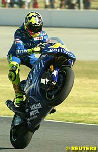 Valentino Rossi celebrates with a wheelie after winning in South Africa