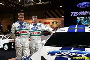 Ford's 2005 drivers Toni Gardemeister and Roman Kresta standing alongside a prototype of the 2006 Focus