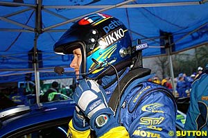 Petter Solberg puts his HANS-equipped helmet on